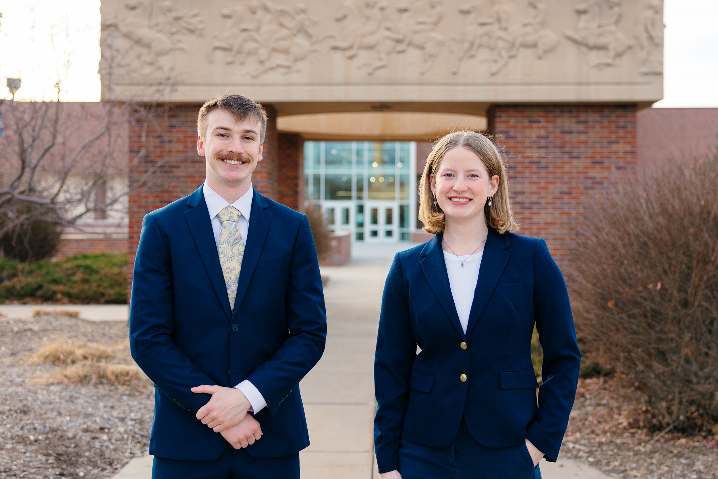 John Placke and Paige Oltmans are pictured in front of the Bell Tower on campus.