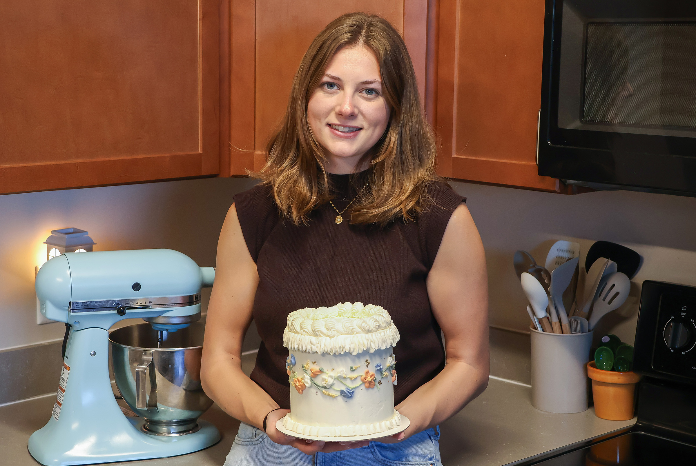 UNK senior Kailynn Rodewald poses for a photo with one of her cakes.