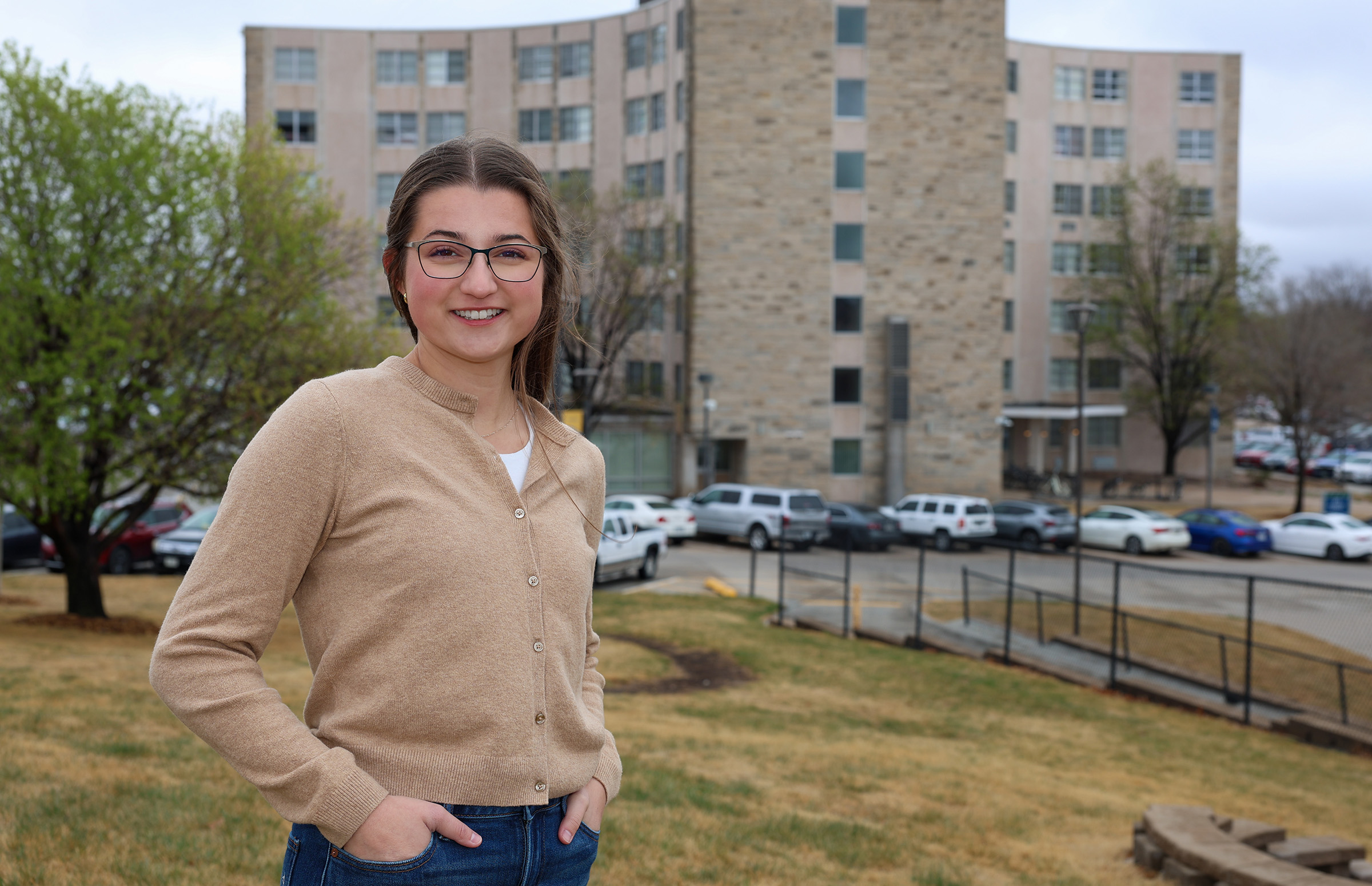 Abby Chambers poses for a photo with the CTE and CTW residence halls in the background.