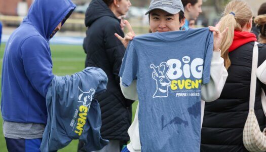 A UNK student poses for a photo at Cope Stadium.