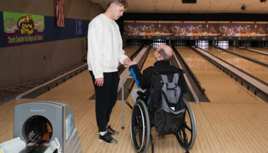 UNK sophomore Evan Kiene assists during Buddy Bowling.