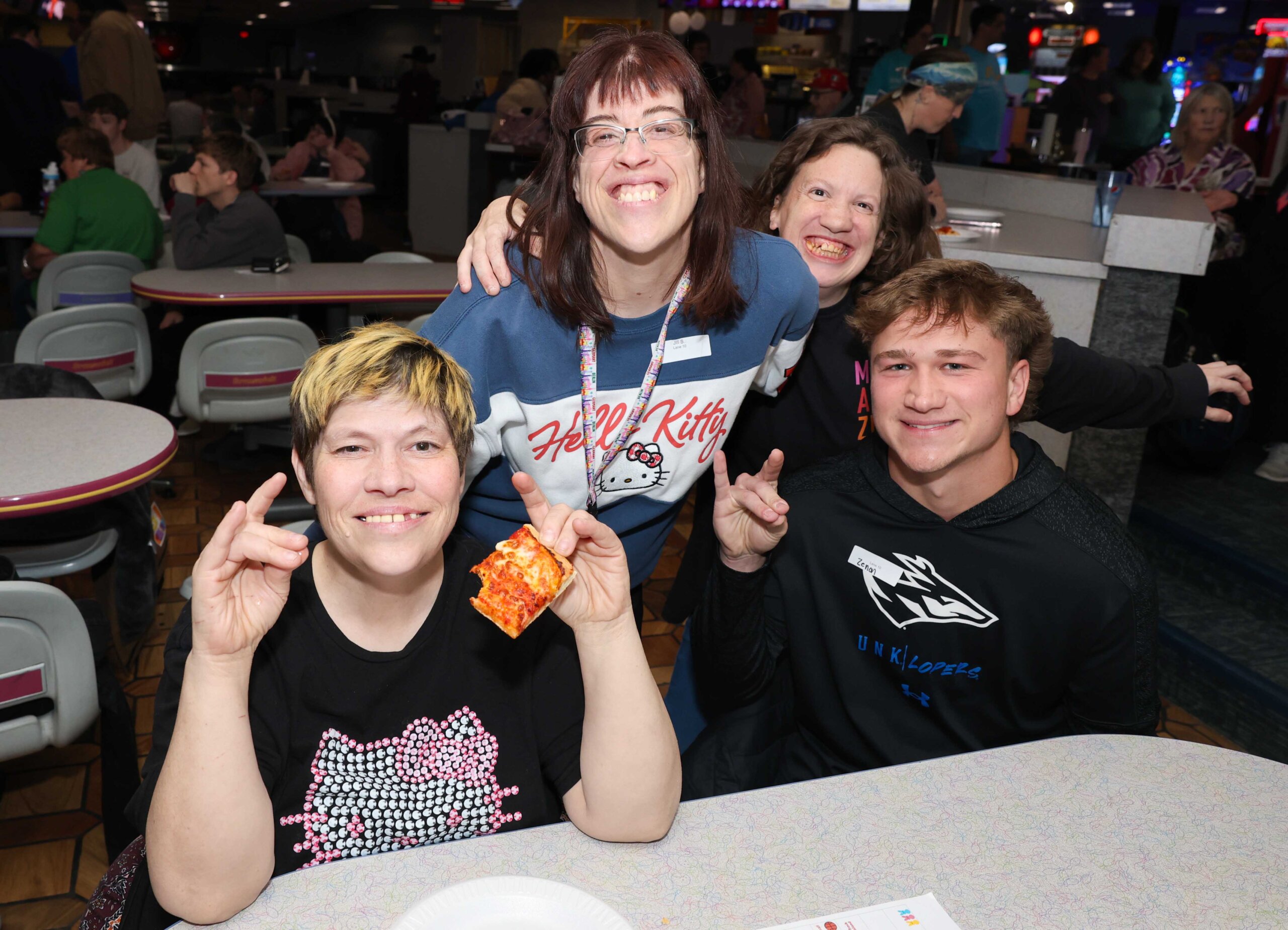 A posed group photo with a UNK student and Buddy Bowling participants.