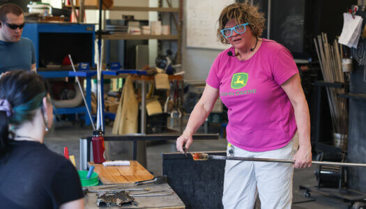 Glassblowing associate professor, Nadine Saylor gives a glassblowing demonstration to her students (Photo by Erika Pritchard, UNK Communications).