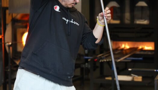 A student shapes glass in the glassblowing studio (Photo by Erika Pritchard, UNK Communications).