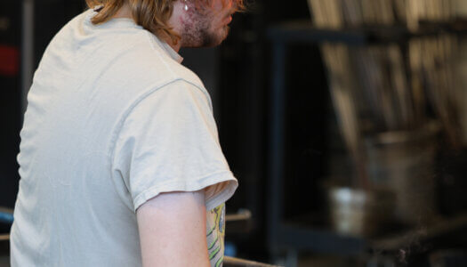 A student shapes glass in the glassblowing studio (Photo by Erika Pritchard, UNK Communications).