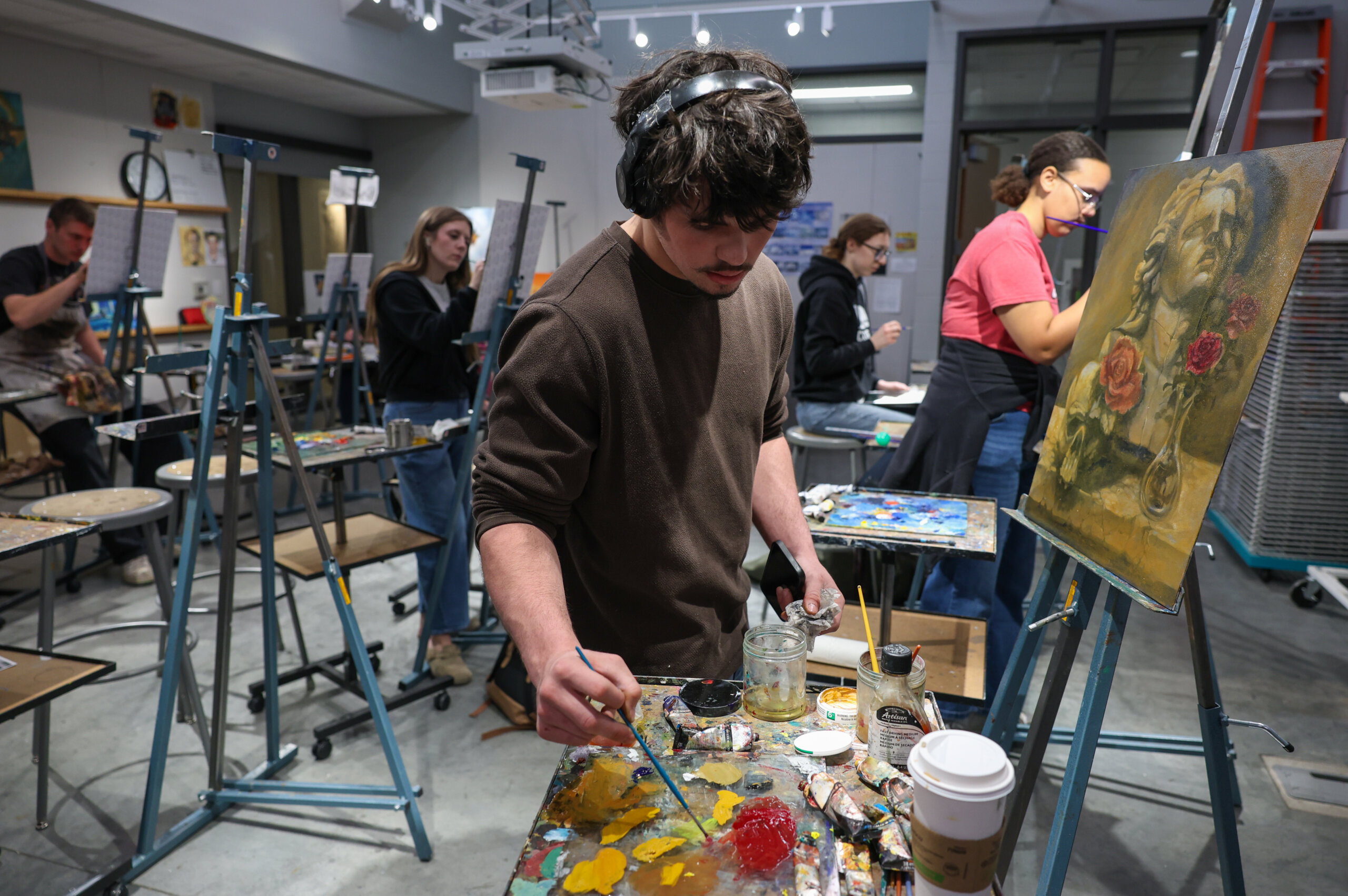 Students paint on canvas.