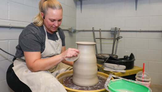 A student creates pottery in ceramics class (Photo by Erika Pritchard, UNK Communications).