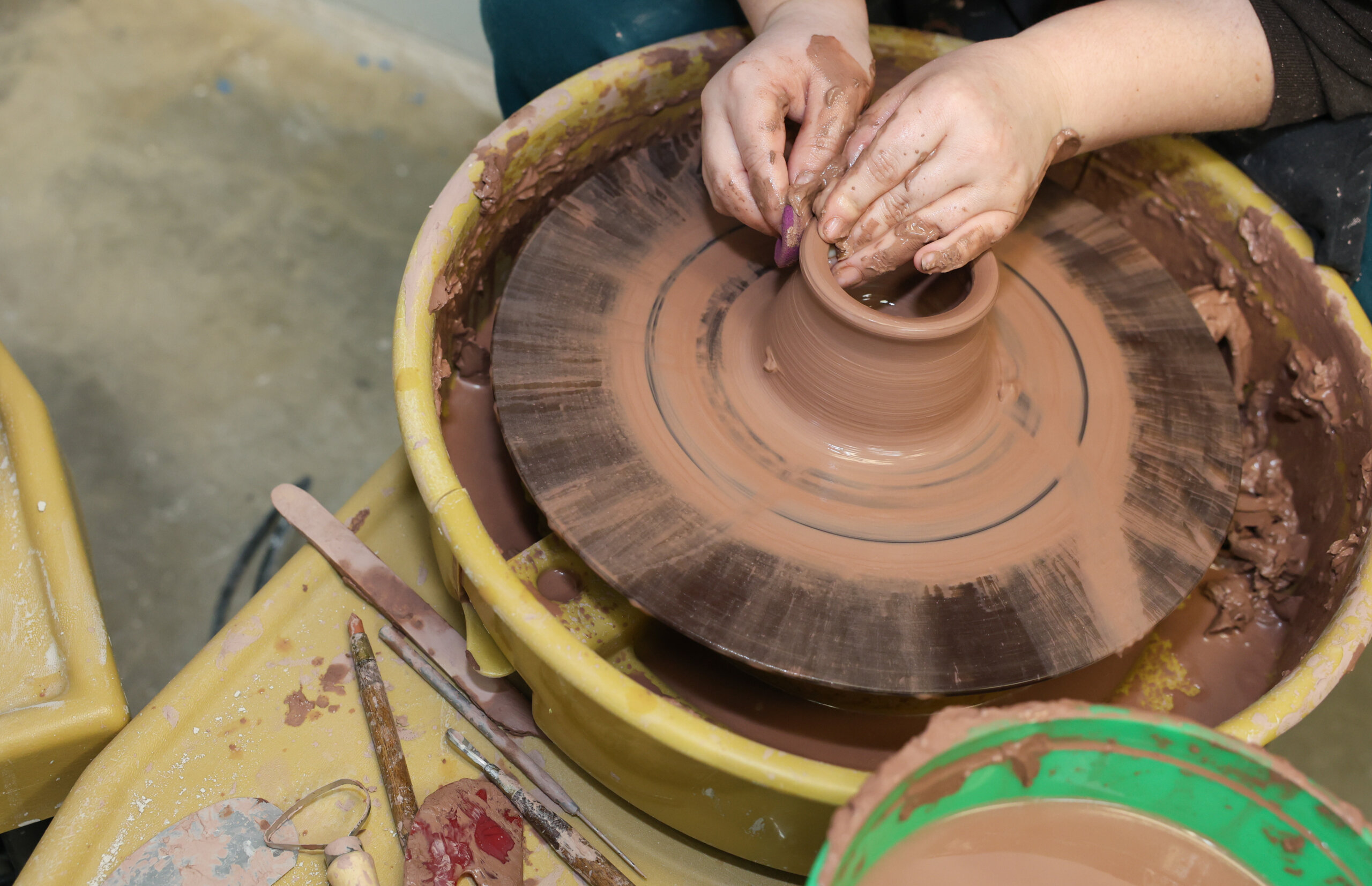 Hands on a pottery wheel.