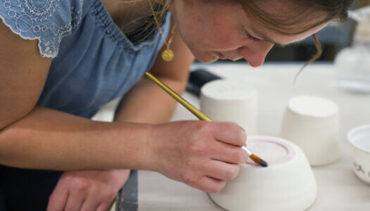 A student paints a piece of pottery in ceramics class (Photo by Erika Pritchard, UNK Communications).