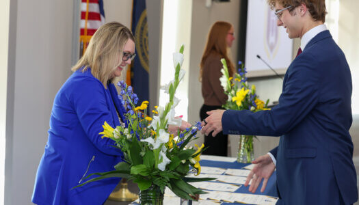 Student Engagement Director Renae Zimmer hands a student a certificate.