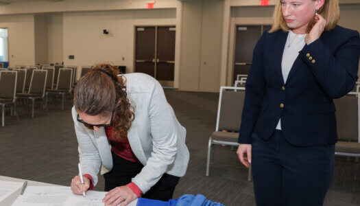 Student Engagement Office Coordinator Amber Gap notarizes a document signed by new UNK student body president Paige Oltmans.