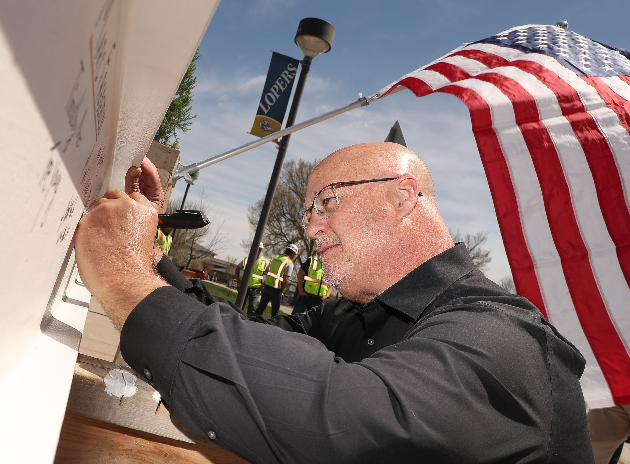 Tim Burkink participates in a ceremonial beam signing for Discovery Hall.