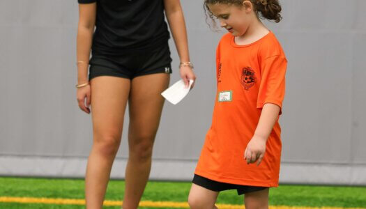 UNK soccer player Camrynn Nitta works with a young girl during TOPSoccer.