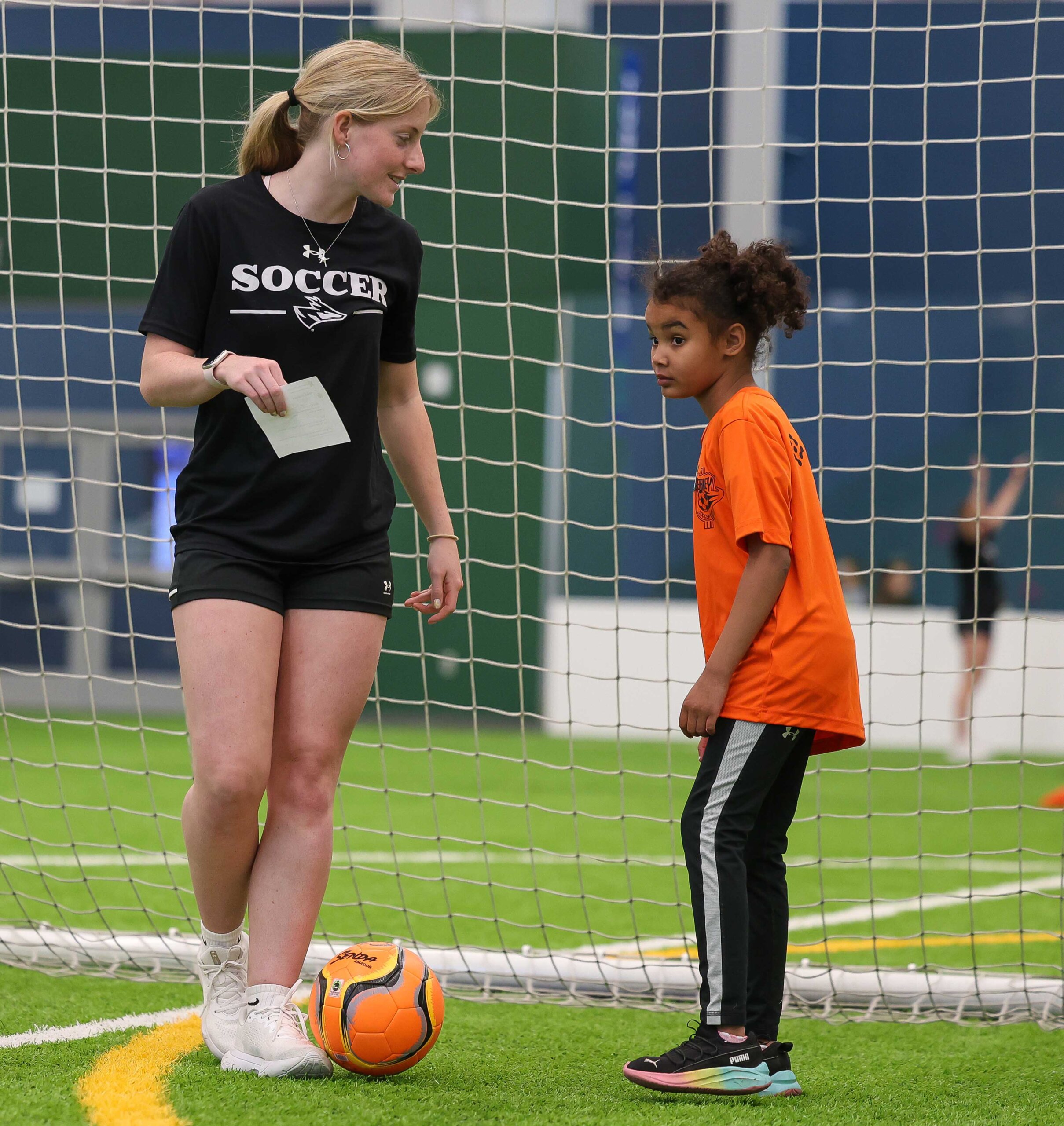 UNK soccer player Chloe Edmunds works with a young girl Monday evening during TOPSoccer at the Kearney SportsPlex.