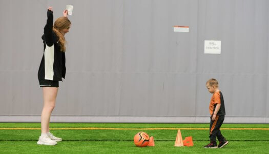 UNK soccer player Jordan Renard cheers on a young boy during TOPSoccer.