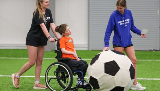 UNK soccer players assists during TOPSoccer.