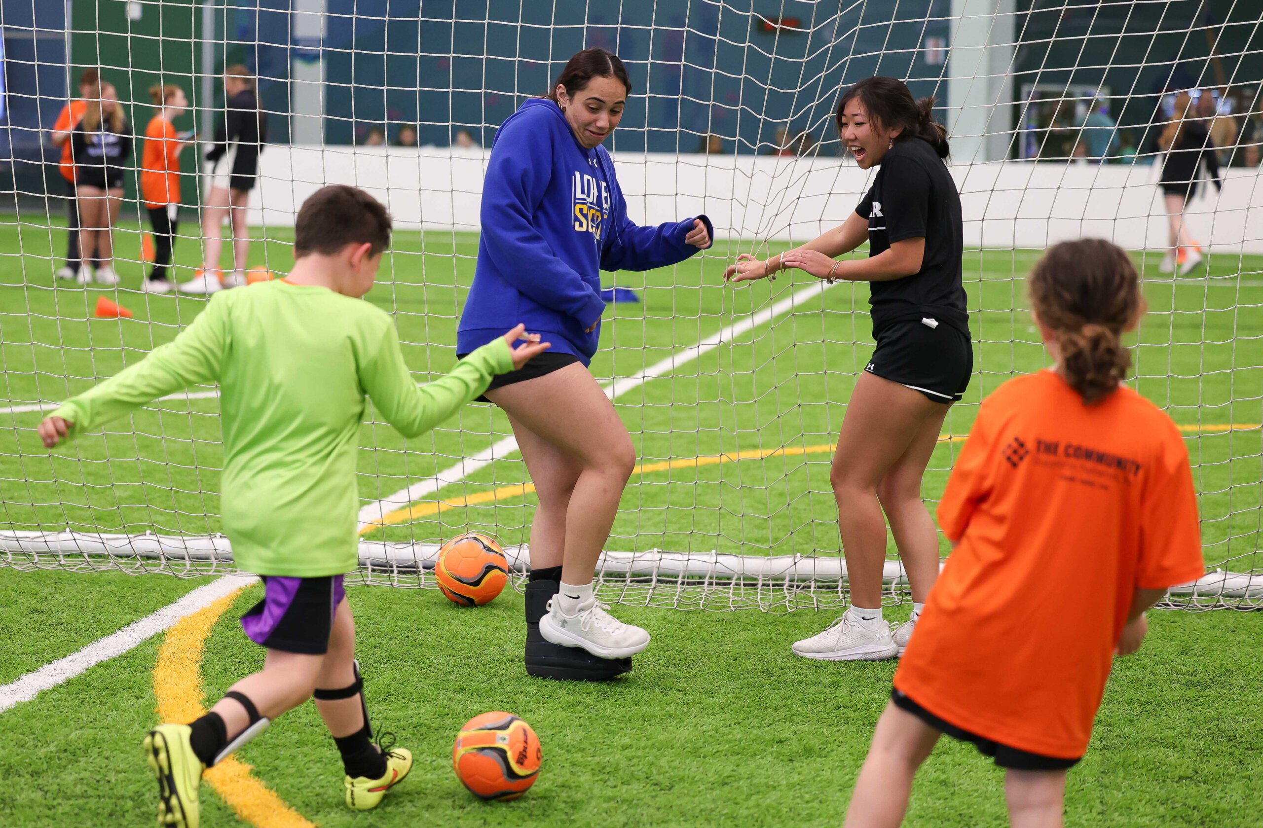 UNK soccer players Serene Hamzeh, left, and Camrynn Nitta have some fun with TOPSoccer participants Monday evening at the Kearney SportsPlex.