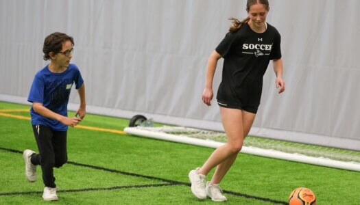UNK soccer player Susie Bovaird works with a young boy during TOPSoccer.