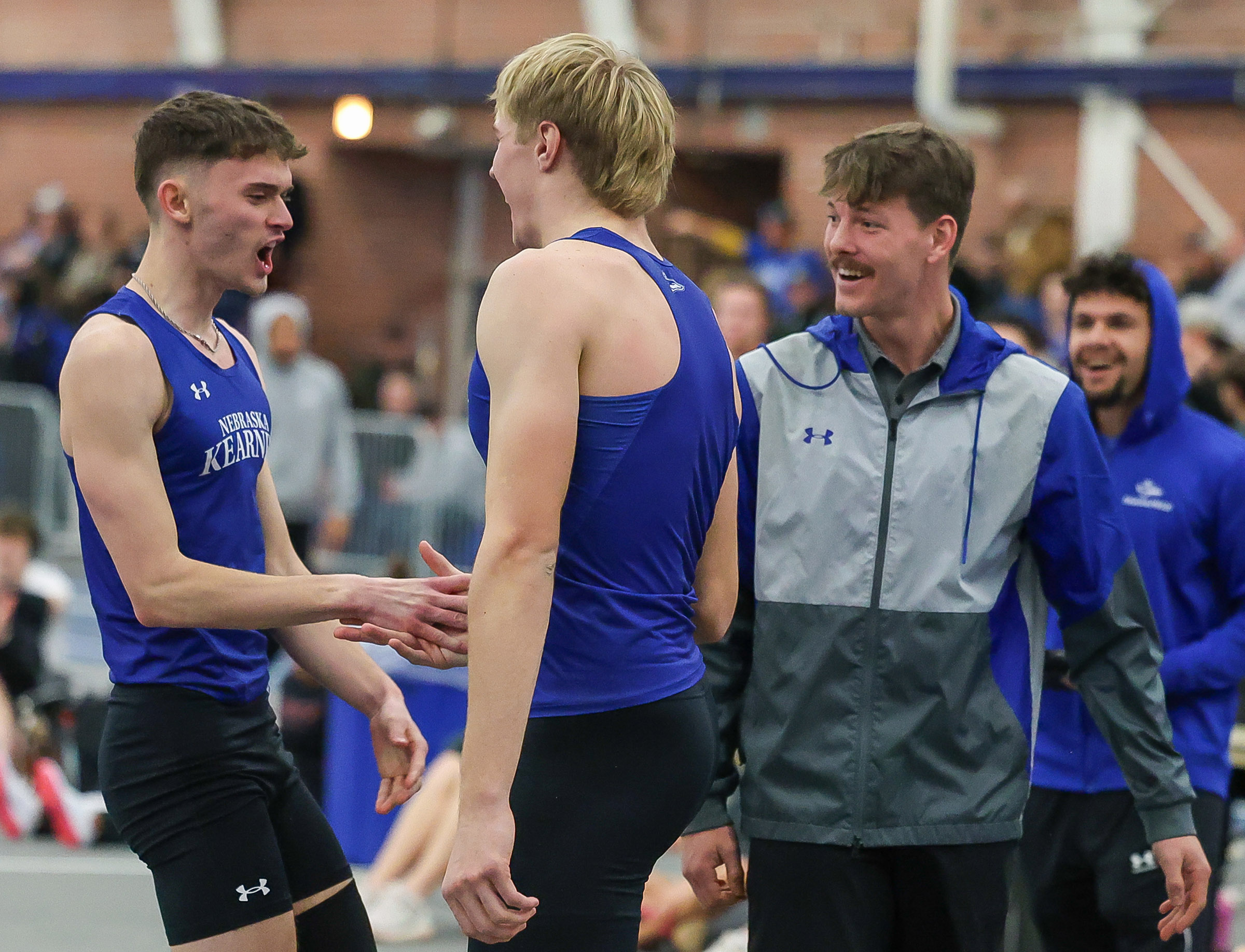 UNK high jumpers Nolan Studley and Luke Brachle celebrate with assistant coach Brayden Sorensen during a meet at Cushing Coliseum on campus.