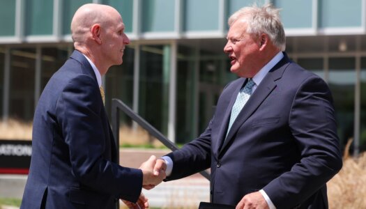 Neal Schnoor and Doug Kristensen shake hands during the Rural Health Education Complex celebration.