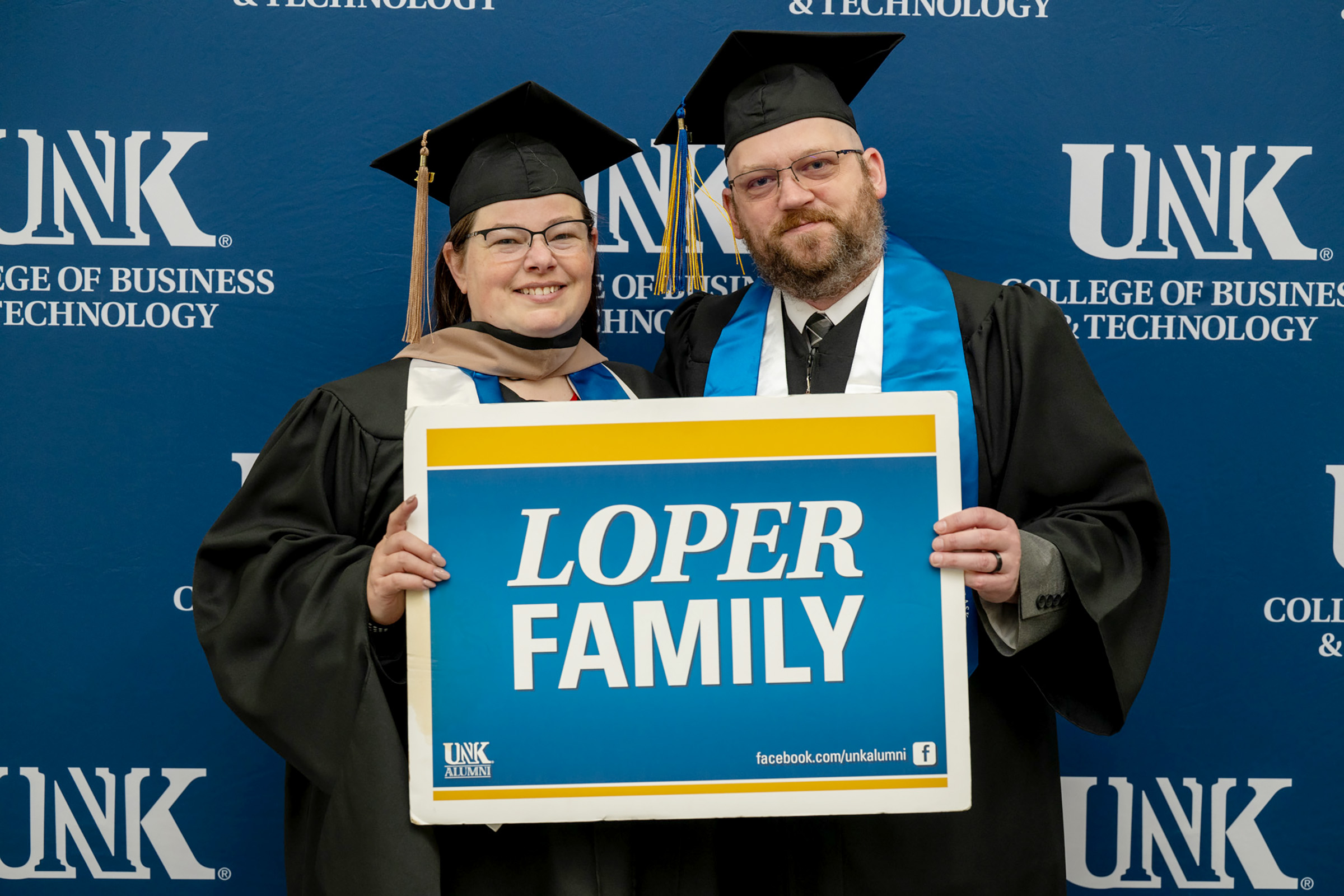 Matthew and Kathy Welte hold a "Loper Family" sign during UNK's spring commencement.