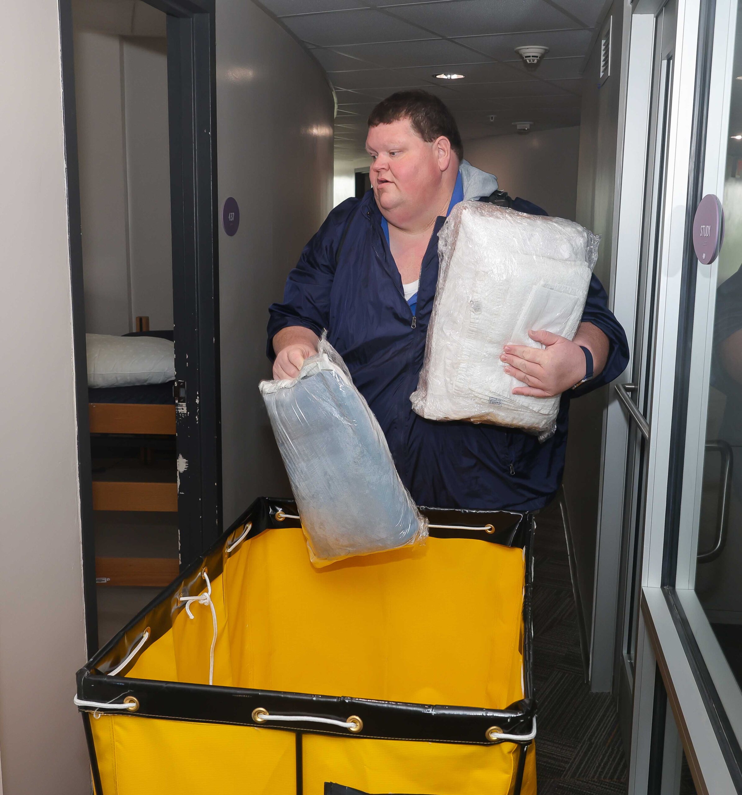 Matt Allbright delivers pillows and sheets to a residence hall room.