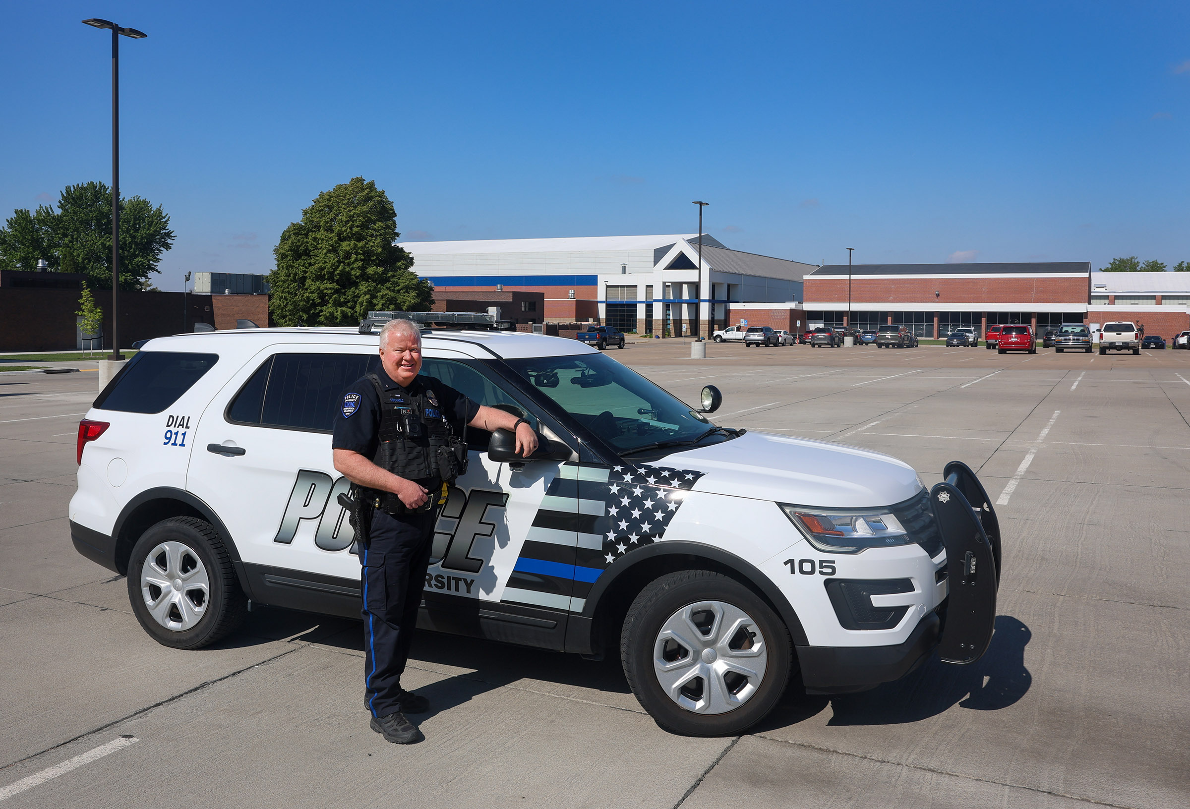 Ted Eichholz poses for a photo with a UNK Police vehicle.