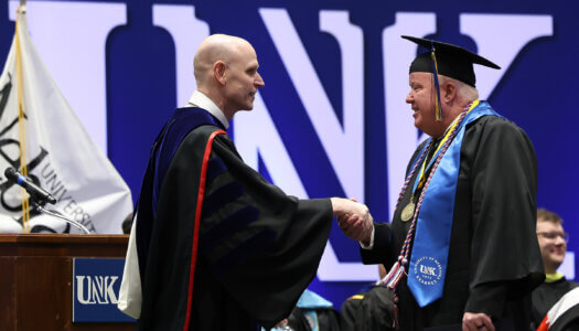 UNK Chancellor Neal Schnoor congratulates Ted Eichholz during the spring commencement ceremony.