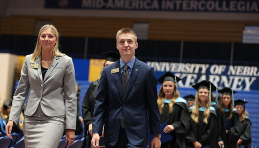 Jocelyn Rauert serves as a Chancellor's Ambassador during a UNK commencement ceremony.
