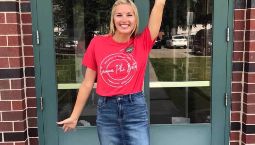 Jocelyn Rauert poses for a photo outside the old Gamma Phi Beta house at UNK.