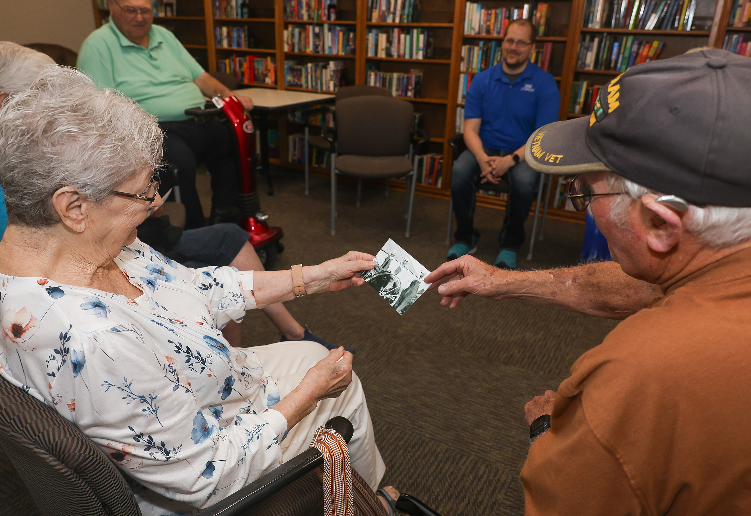Robert “Bob” Johnson shares some of his family photos during a weekly reminiscence therapy group meeting at the Peterson Senior Activity Center in Kearney.