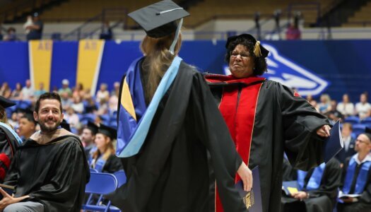 UNK Professor Toni Hill congratulates a student.