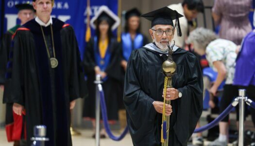 Akbar Javidi carries the mace.