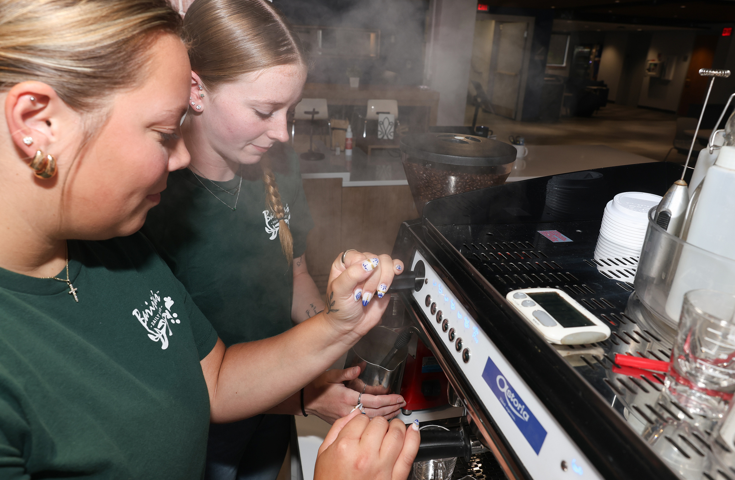 Barista’s Daily Grind employees Alison Brown, back, and Macy Cline prepare the new UNK location for its Monday opening.
