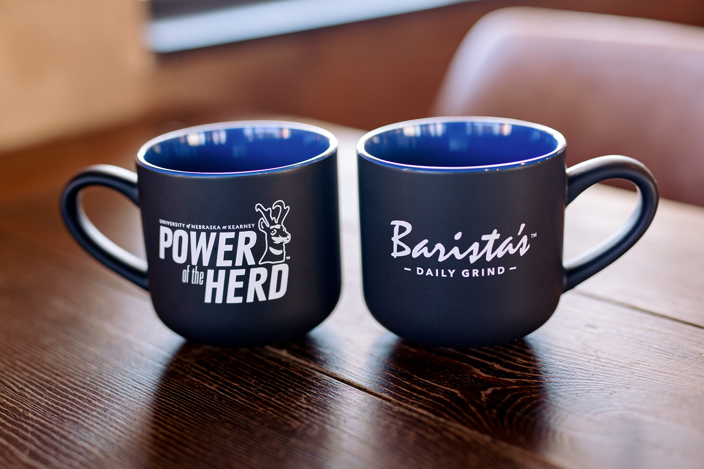 Barista's Daily Grind mugs with UNK branding.