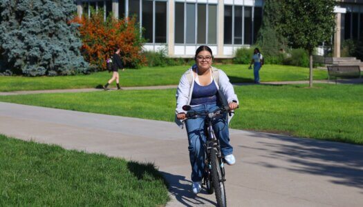A student rides her bike across campus.