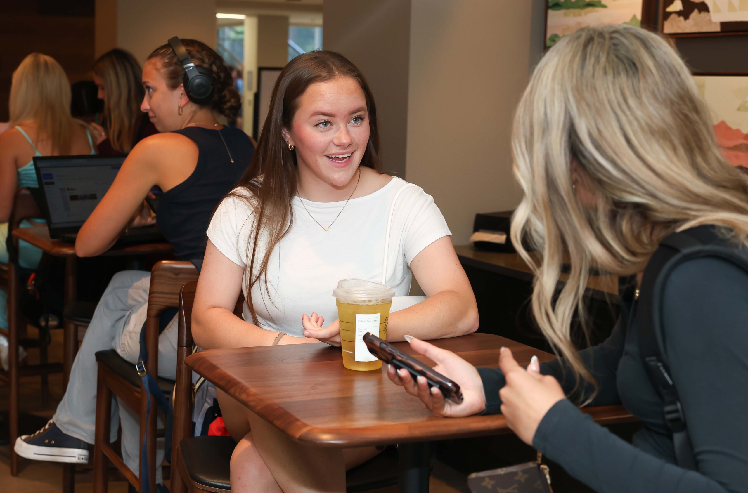 Students converse at a coffee shop.