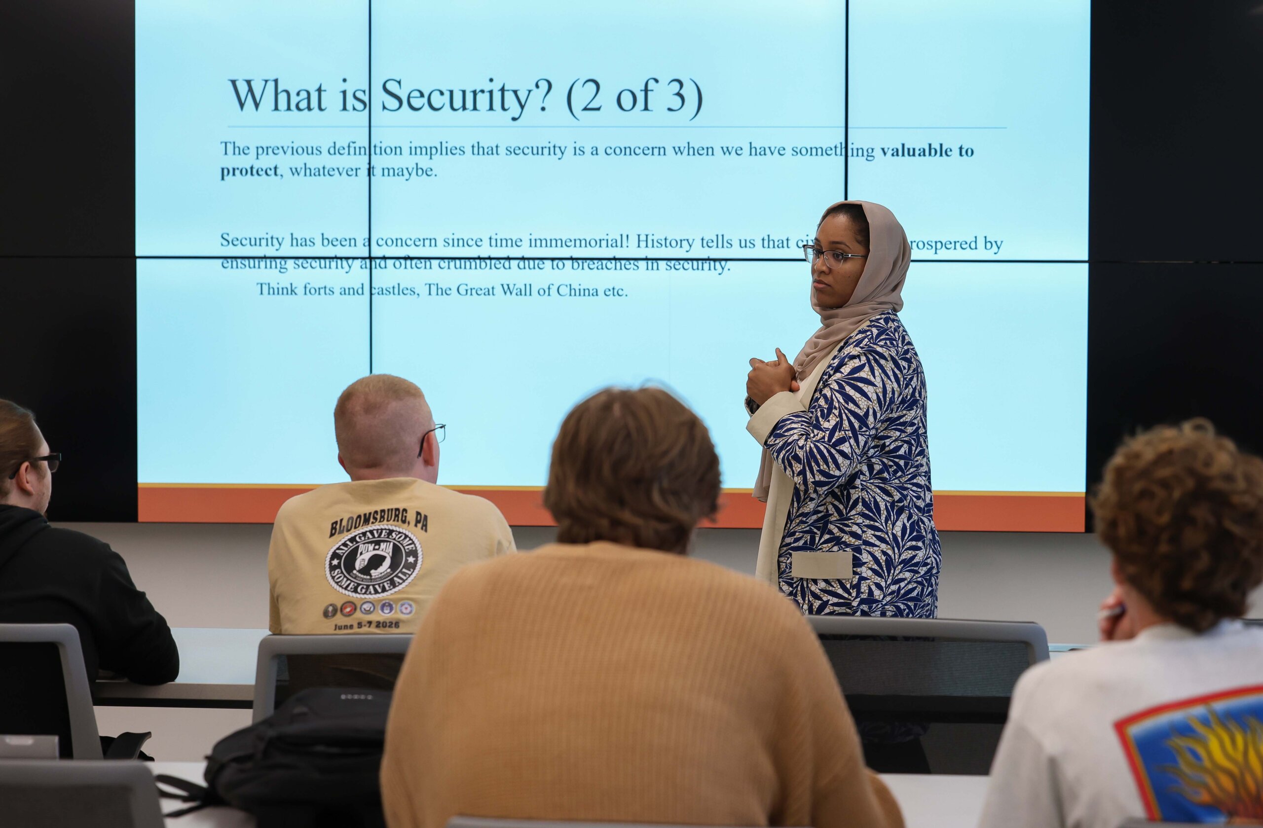A professor teaches at the front of the classroom.