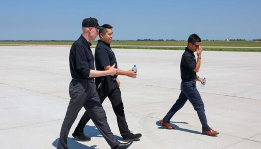 Neal Schnoor, Masahiro Suzuki and Ryo Suzuki walk along the taxiway.