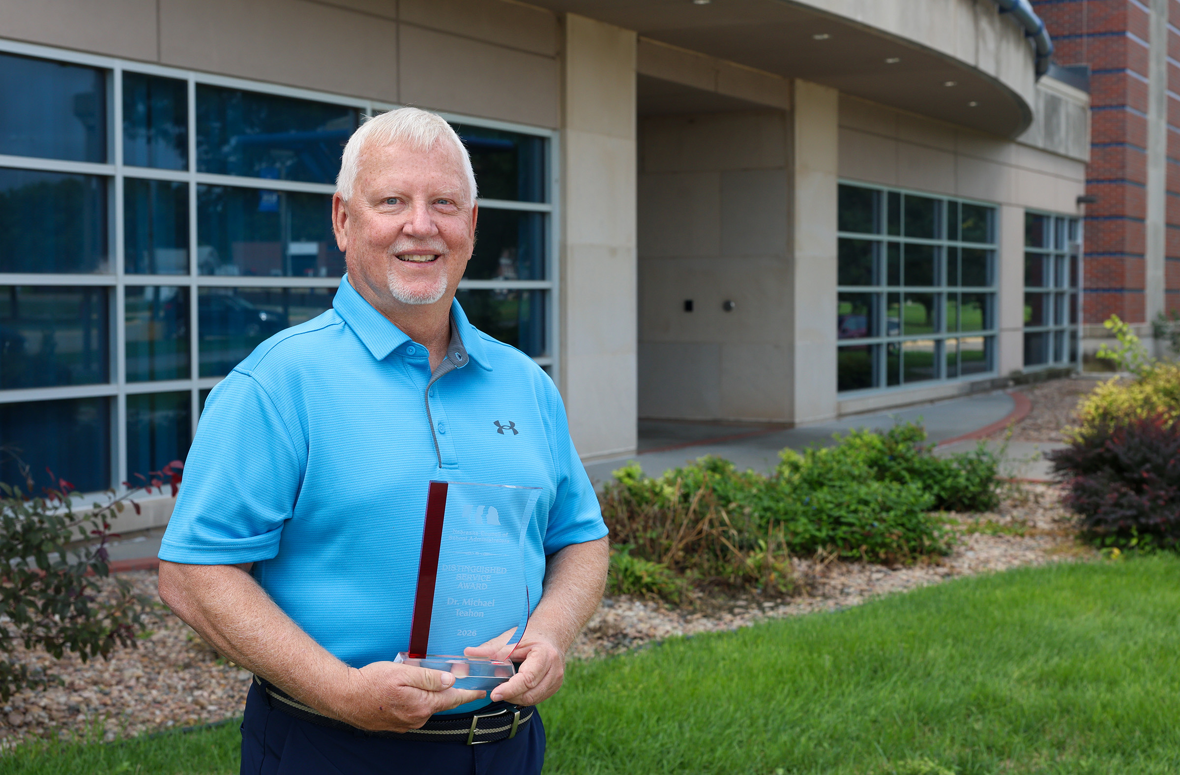 Mike Teahon poses for a photo outside the UNK College of Education.