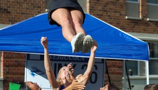 UNK Cheer does a stunt at Blue Gold Showcase.
