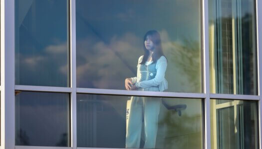 A student watches Blue Gold Showcase from a residence hall.