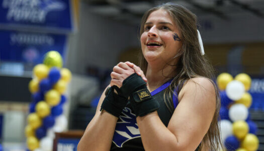 A cheerleader chants at convocation.