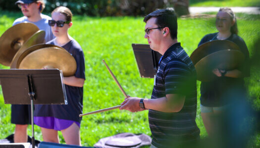 Tyler Hawk works with percussion students during marching band camp.