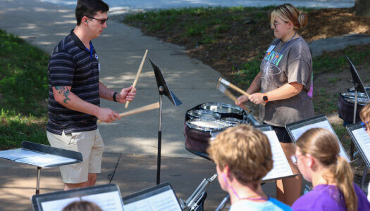Tyler Hawk works with percussion students during marching band camp.