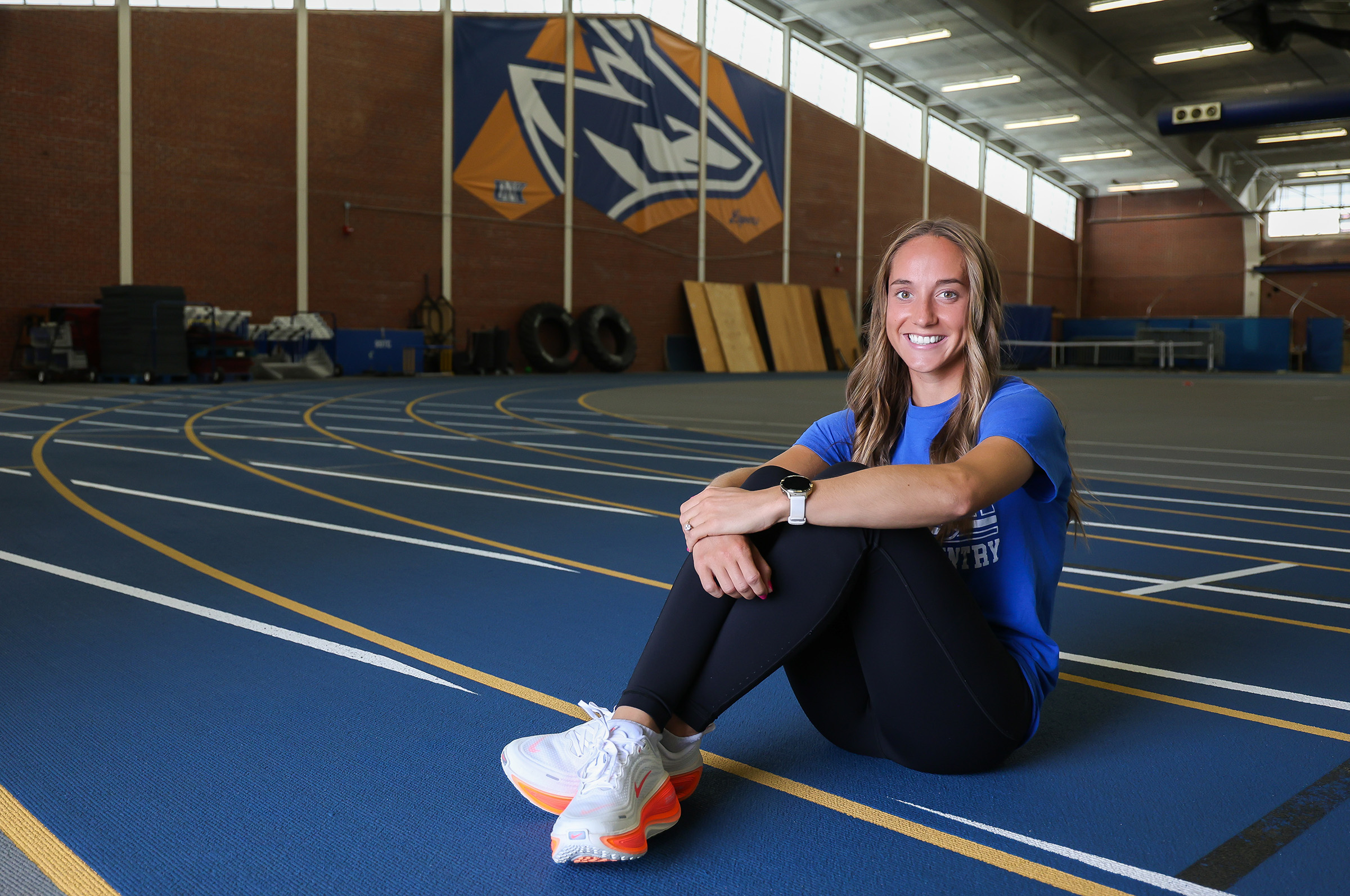 Kassidy Stuckey poses for a photo on the track inside UNK's Cushing Coliseum.