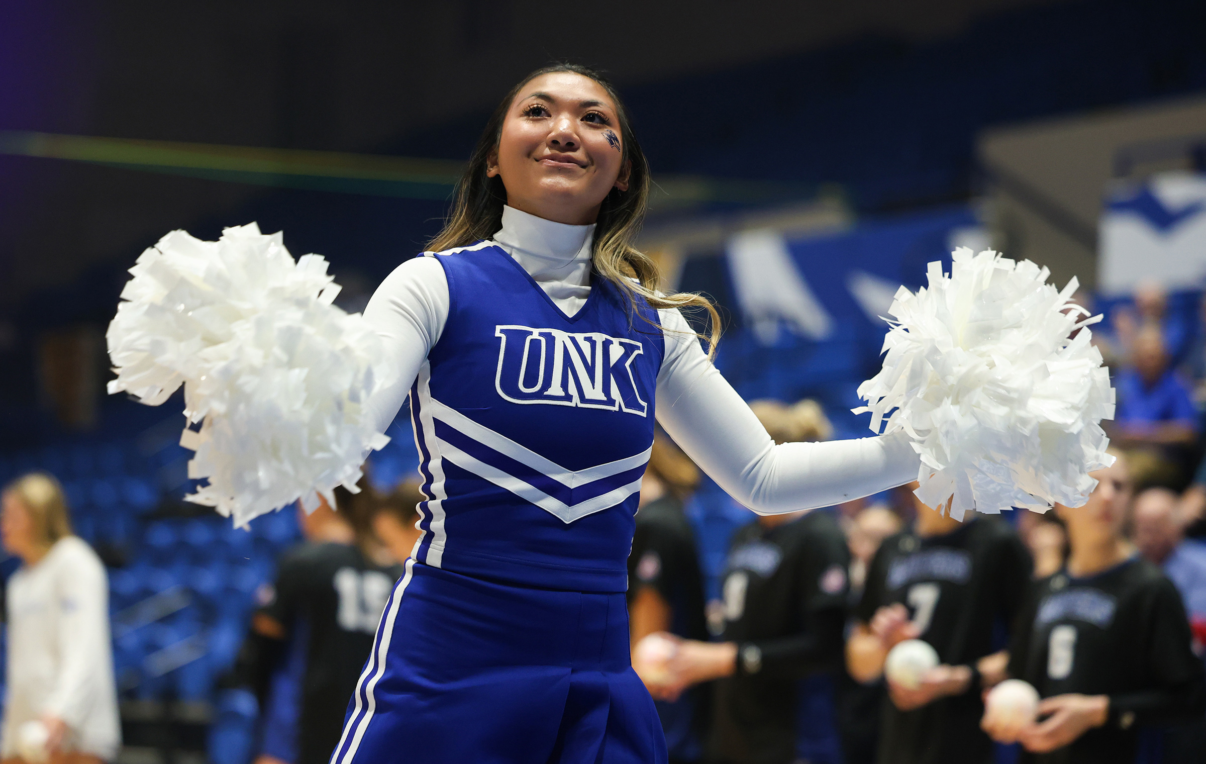 Nikki Sonthana cheers during a UNK volleyball match.