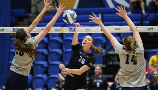 Sydney Davis splits two defenders with an attack during a home match.