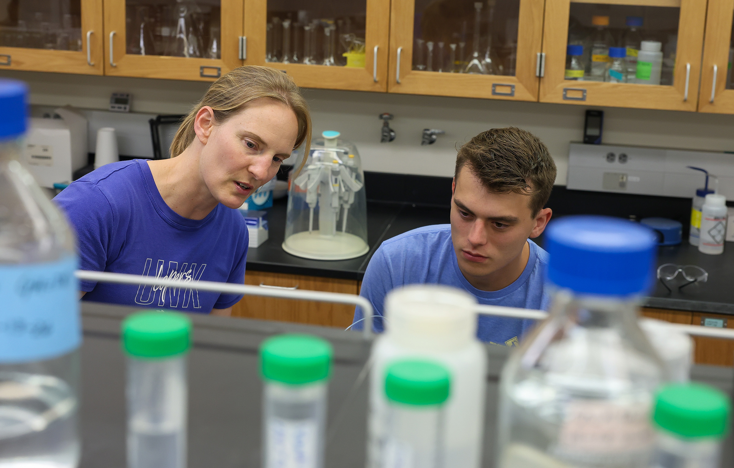 Annette Moser works with a student in a chemistry lab.