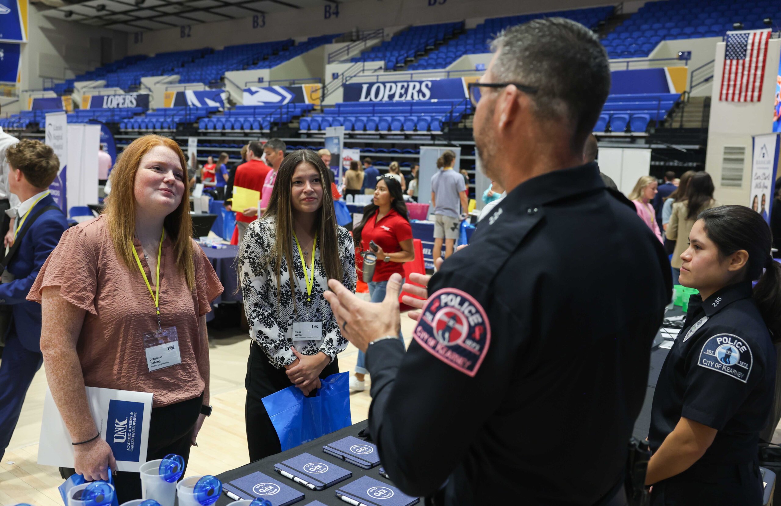 UNK students Johannah Bohling and Paige Winter meet with representatives from Kearney Police Department during Thursday’s Career and Internship Fair.